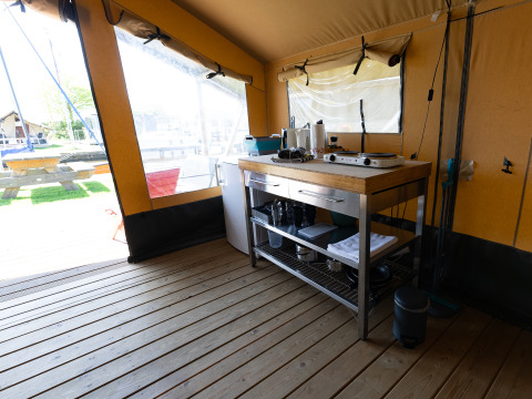 Vista interior de la zona de cocina en la Safari tent Heeg, en Marina Heeg, Países Bajos, con suelo de madera.