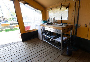 Vue intérieure de la cuisine de la Safari tent Heeg à Marina Heeg, Pays-Bas, avec sol en bois et vue dehors.