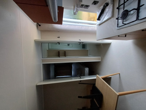 Piccola cucina in una sistemazione glamping con fornello a gas, tavolo, sedie e uno specchio a parete.