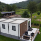 Alloggio glamping moderno con terrazza e posti a sedere all'aperto in un ambiente verde e naturale.