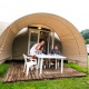 Famiglia si gode un pasto davanti a una tenda safari Coco Sweet presso un campeggio immerso nel verde.