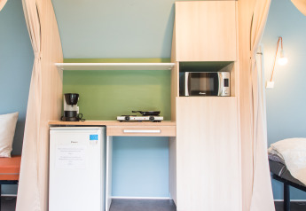 Compact kitchenette setup inside a Coco Sweet safari tent at Camping La Colline in Belgium.
