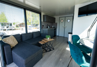 Stue og køkkenområde på Houseboat Heeg ved Marina Heeg i Holland med moderne møbler og store vinduer.