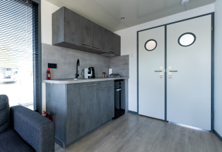 Angolo cottura moderno nella Houseboat Heeg con mobili grigi, situato presso Marina Heeg nei Paesi Bassi.