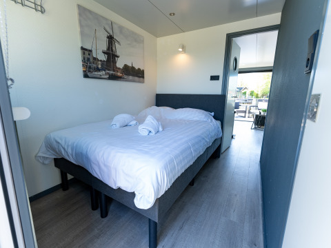 Bedroom on Houseboat Heeg at Marina Heeg, Netherlands, with a double bed and minimalist modern decor.