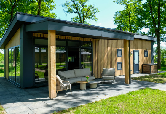 Vista exterior de la Wood Cottage con terraza moderna en Holiday park De Witte Berg, Países Bajos.