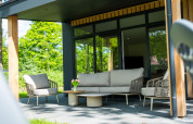 Moderne terras aan Wood Cottage, vakantiepark De Witte Berg, Nederland, met tuinmeubilair.