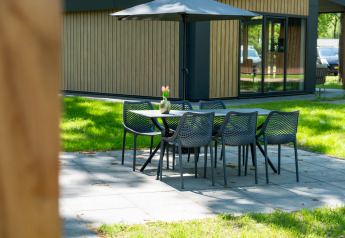 Udendørs spiseområde ved Wood Cottage på Holiday park De Witte Berg, med et bord, stole og parasol.