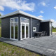Moderne sort Turfsteker Chalet ved De Tien Heugten i Holland med stor terrasse og havemøbler.