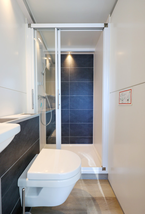 Moderne badeværelse med væghængt toilet og brusekabine på husbåd 'De Hoop' i Nederlandene.