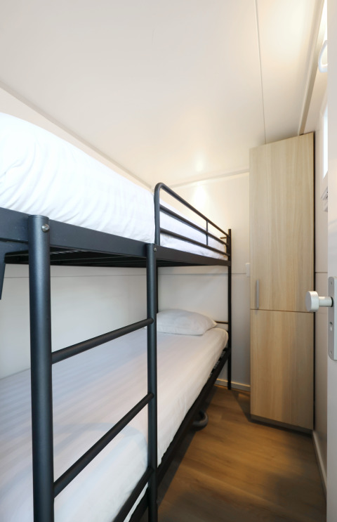 Habitación con litera y armario en la casa flotante 'De Hoop' en Marina Parcs - Jachthaven De Hoop en los Países Bajos.