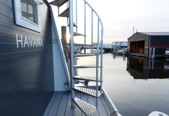 Escalera de caracol en una casa flotante en Marina Parcs - Jachthaven De Hoop, Países Bajos, al atardecer.