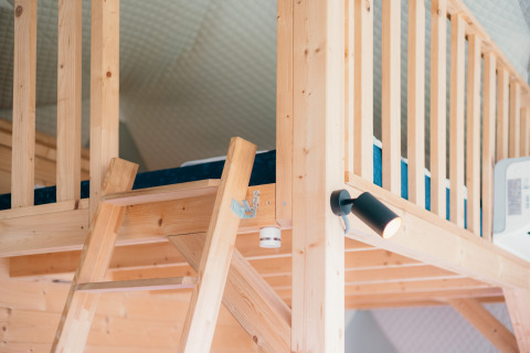 Ático de madera con escalera y cama en Round Holly Tent en Holiday Park Sallandshoeve, Países Bajos.