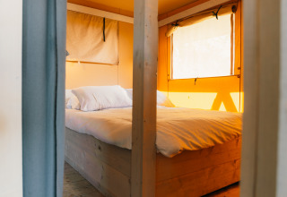 Acogedor dormitorio con cama doble en tienda safari, Safari cottage, Holiday Park Sallandshoeve, Países Bajos.