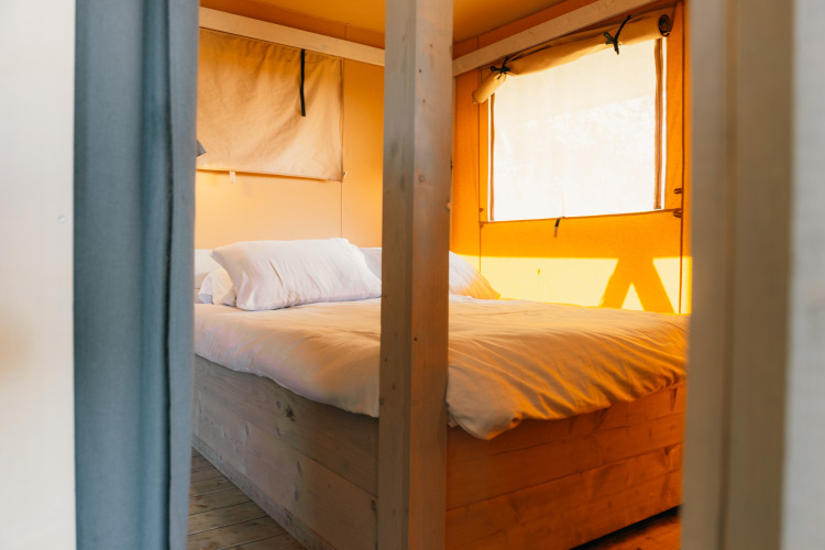 Acogedor dormitorio con cama doble en tienda safari, Safari cottage, Holiday Park Sallandshoeve, Países Bajos.