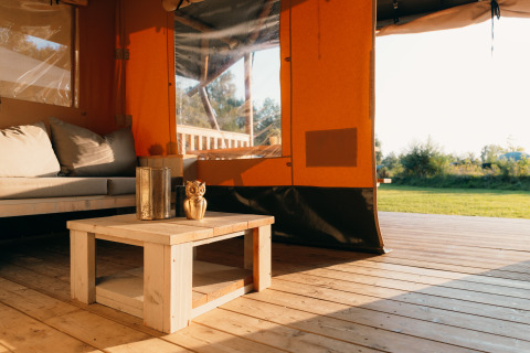 Intérieur de la tente Safari cottage au Holiday Park Sallandshoeve, avec coin salon et vue sur la nature.