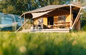 Safaritent Safari cottage op Vakantiepark Sallandshoeve, Nederland, met veranda, bank en picknicktafel.