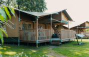 Tienda safari llamada Ranger Lodge con terraza de madera en Holiday Park Sallandshoeve, Países Bajos.