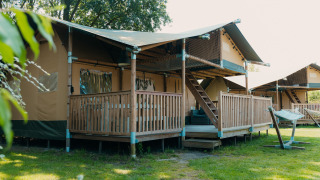 Tente safari nommée Ranger Lodge avec terrasse en bois au Holiday Park Sallandshoeve aux Pays-Bas.