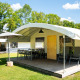 Tenda safari chiamata Tentvilla al villaggio De Witte Berg nei Paesi Bassi, con veranda e sedie.