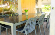 Table à manger extérieure avec chaises modernes et vase de fleurs à la Tentvilla du parc De Witte Berg.