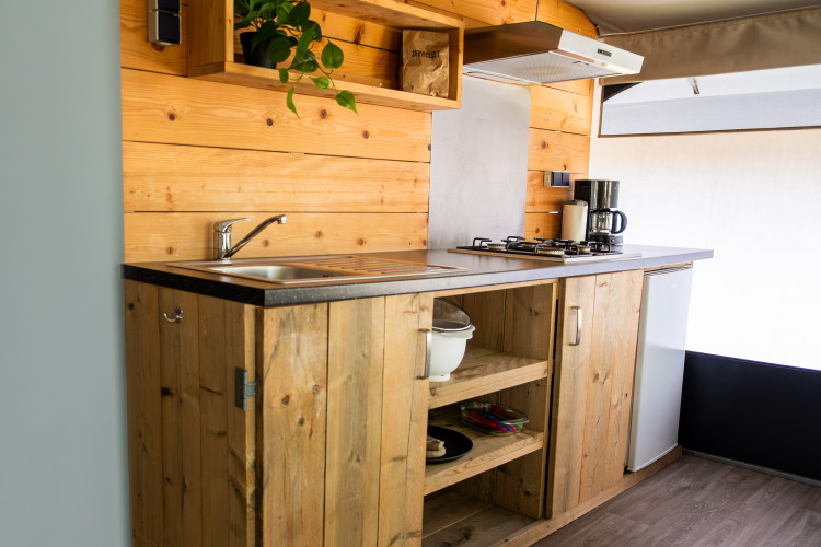 Cocina en una tienda safari, Tentvilla en Holiday park De Witte Berg, Países Bajos, con muebles de madera.
