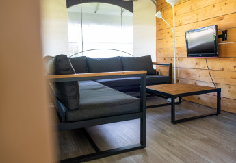 Moderne zithoek in safaritent Tentvilla bij Holiday park De Witte Berg met houten wand en banken.