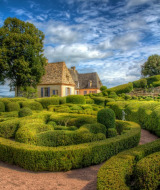 Labirinto di siepi ben curato e casa tradizionale vicino a Saint-Astier, Nouvelle-Aquitaine, Francia.