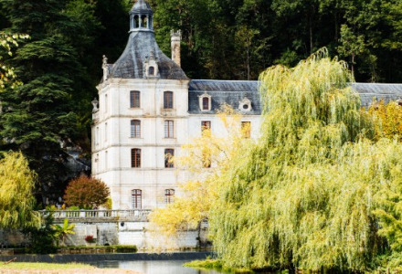Un suggestivo castello vicino a un lago calmo, tra alberi lussureggianti presso Saint-Astier, Nouvelle-Aquitaine, Francia.