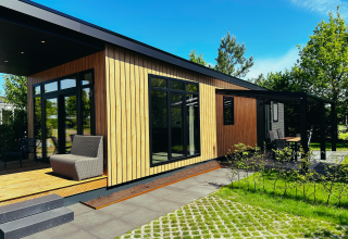 Sunlodge bij Vakantiepark 't Rheezerwold in Nederland, moderne houten lodge met terras en tuin.