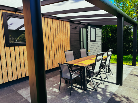 Udendørs terrasse ved Sunlodge i Holiday Park 't Rheezerwold, Holland, med spisebord og seks stole.