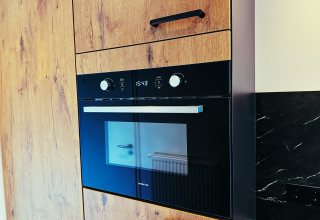 Inbouwoven in moderne houten keuken van Sunlodge op Holiday Park 't Rheezerwold, Nederland.