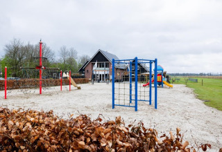 Aire de jeux au parc de vacances The Kremmer à Drenthe, Pays-Bas, avec toboggans et jeux d’escalade.