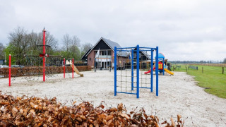 Speeltuin bij vakantiepark The Kremmer in Drenthe, Nederland, met klimrekken en glijbanen.