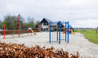 Speeltuin bij vakantiepark The Kremmer in Drenthe, Nederland, met klimrekken en glijbanen.