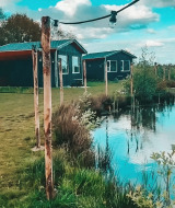 Vakantiehuisjes, sfeerverlichting en vijver in The Kremmer vakantiepark te Drenthe, Nederland.