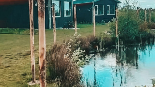 Vakantiehuisjes, sfeerverlichting en vijver in The Kremmer vakantiepark te Drenthe, Nederland.