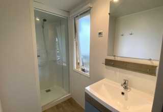 Modern badkamer in de Stacaravan op Camping Le Céou, Frankrijk, met douche, wastafel en spiegel.
