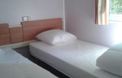 Foto di una camera in una cabina con due letti singoli allo Stacaravan met airco, Camping Le Céou, Francia.