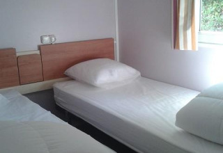 Foto di una camera in una cabina con due letti singoli allo Stacaravan met airco, Camping Le Céou, Francia.