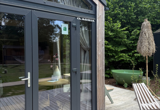 Terrasse und Glastüren des Tiny Home MET DUTCHTUB - GENT bei Urban-Gardens in Belgien.