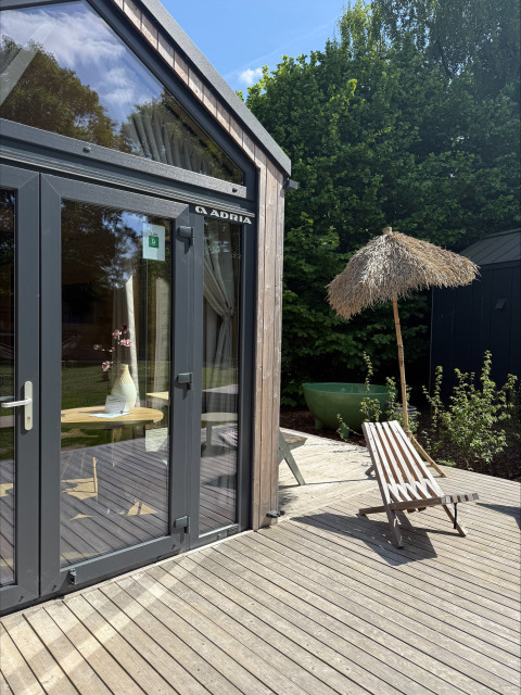 Terraza exterior en Tiny Home MET DUTCHTUB - GENT en Urban-Gardens, Bélgica, con silla y sombrilla.