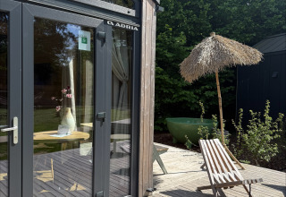 Terraza exterior en Tiny Home MET DUTCHTUB - GENT en Urban-Gardens, Bélgica, con silla y sombrilla.