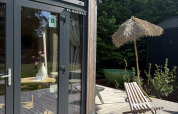Outdoor deck at Tiny Home MET DUTCHTUB - GENT in Urban-Gardens, Belgium, with lounge chair and umbrella.