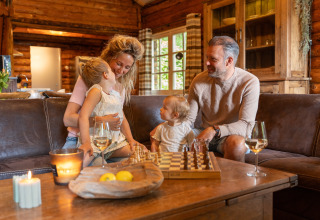 Family relaxing in a wooden lodge at Huys van de Boswachter with hot tub at Sandberghe in the Netherlands.