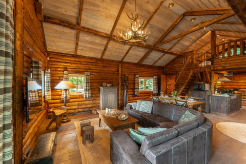 Acogedora cabaña de madera con sala abierta, comedor y cocina rústica en Sandberghe, Países Bajos.