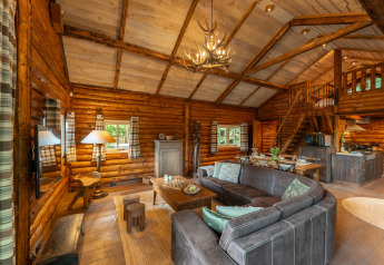 Knusse lodgeinterieur van Huys van de Boswachter met zithoek, eethoek en keuken in Sandberghe, Nederland.