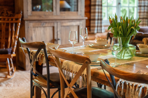 Tavolo rustico apparecchiato con tulipani nel lodge Huys van de Boswachter a Sandberghe, atmosfera calda.