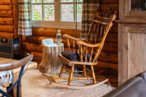 Sedia a dondolo in legno vicino alla finestra in un'accogliente baita a 'Huys van de Boswachter', Sandberghe.