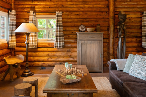 Gemütliches Blockhausinterieur im Huys van de Boswachter mit Schachspieltisch und rustikalen Holzmöbeln in Sandberghe.
